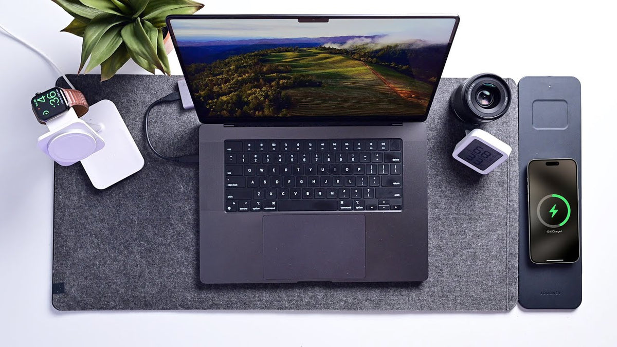 Grey 4-in-1 wireless charging desk mat with laptop, smartphone charging and smartwatch on a tidy home office desk