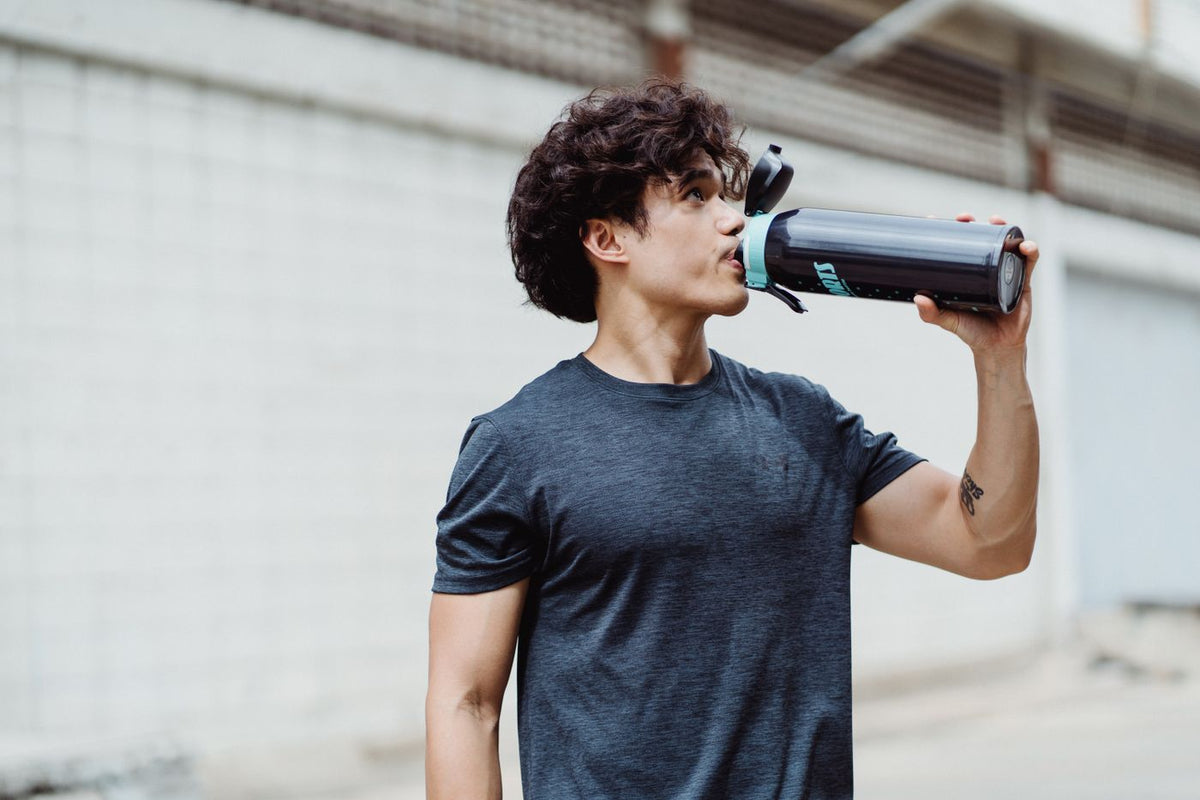 Young man drinking from a sports bottle